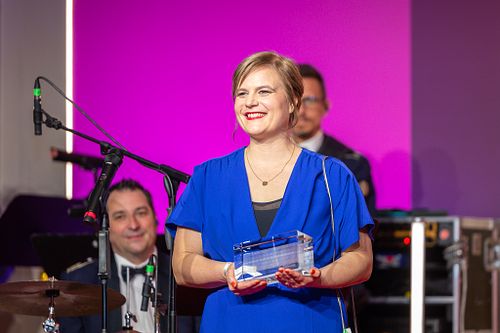 Nadine Lindner, in blue holding an award at the Bundespresseball 2024 ceremony at Adlon Hotel.