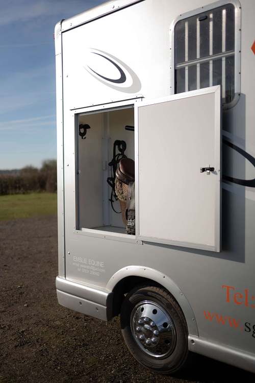 Converted horse box parked outdoors with side hatch open