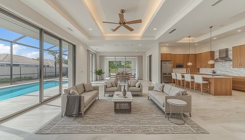 Professional real estate photography by PrimePropertyPhoto showing a modern open-concept living room and gourmet kitchen in Gainesville, FL, featuring sliding glass doors that open to a luxury screened-in pool.