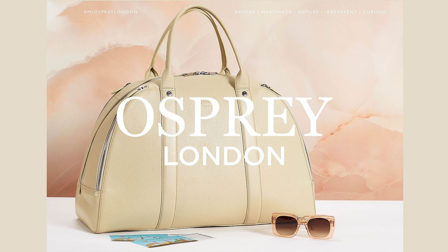 large leather handbag and sunglasses against a marble background