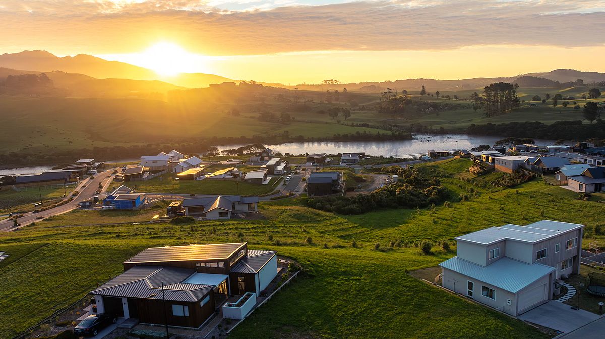 Cinematic sunset drone view of the Rangitahi Peninsula development by Flax Cove Studio.