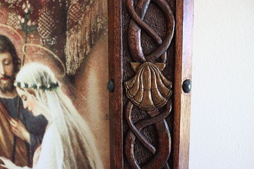 detail of a shell carving on the picture frame surrounded by Norse knotwork and colored beads