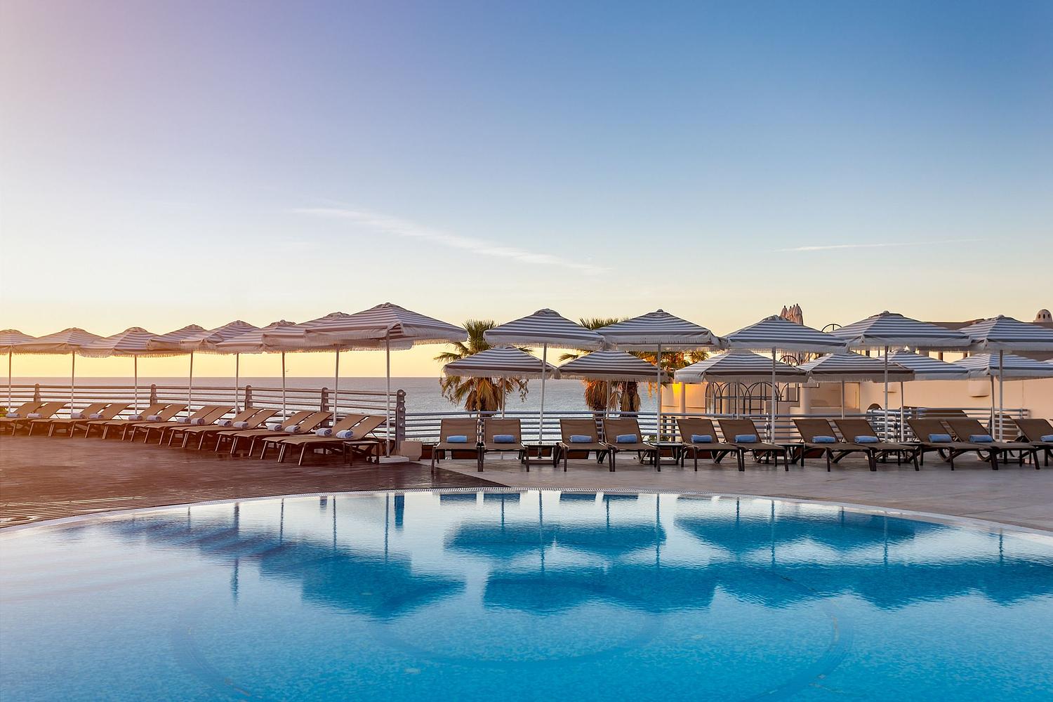 Piscina exterior de resort no Algarve ao entardecer &ndash; fotografia de hotelaria.