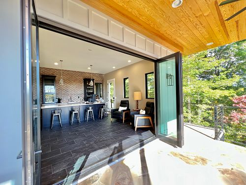 Open glass bifold wall leading to Man Cave