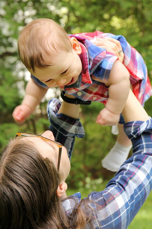 Mom lifts up smiling baby