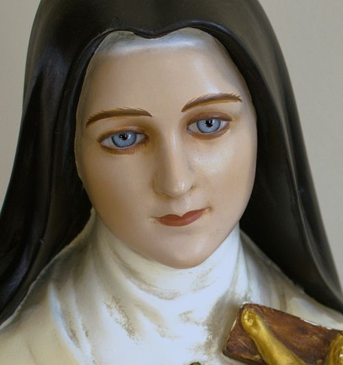 A close-up of the St. Therese statue's face before restoration