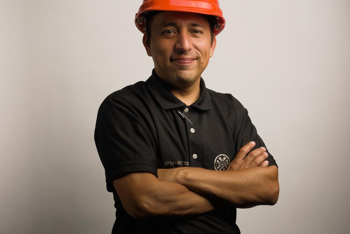 Retrato de un profesional o especialista usando un casco naraja, para uso en sitio web, tarjetas personales y folletos publicitarios.