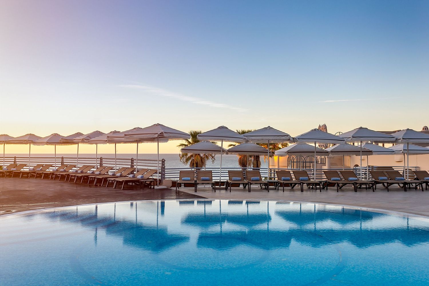 Piscina exterior de resort no Algarve ao entardecer &ndash; fotografia de hotelaria.