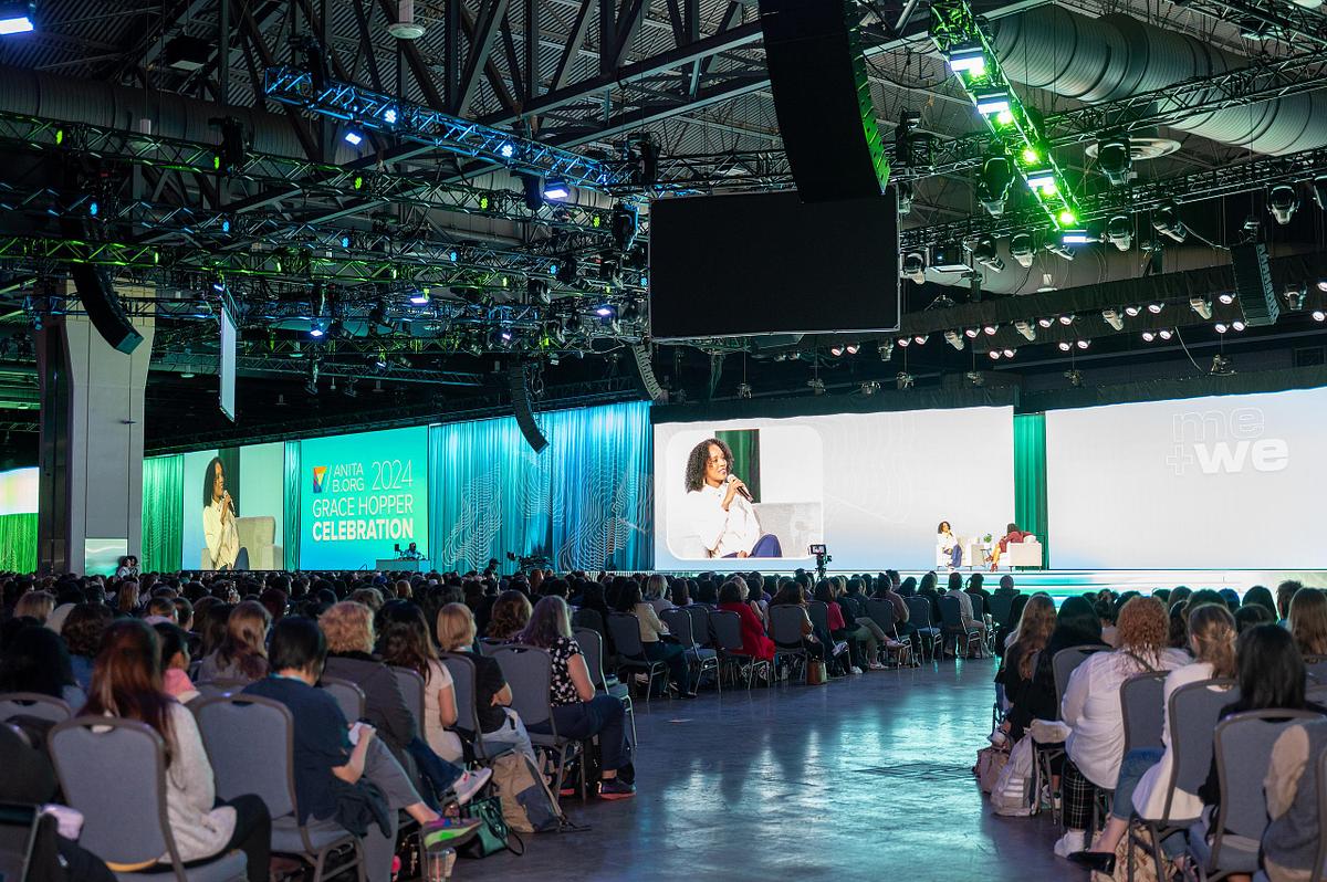 Corporate event photography capturing a keynote session at the 2024 Grace Hopper Celebration in Philadelphia, showcasing large-scale conference production, professional stage lighting, and audience engagement.
