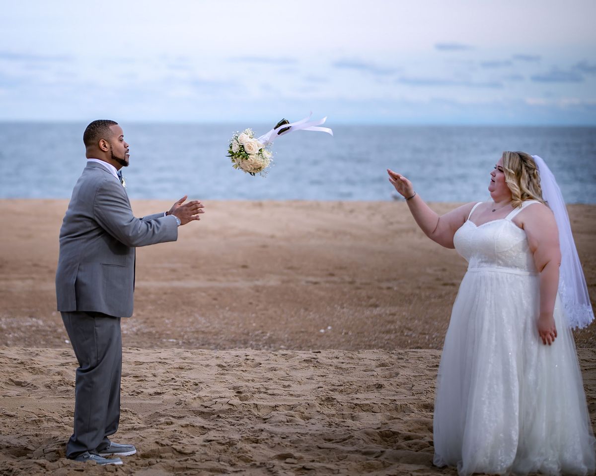 Creative wedding bouquet toss on the shoreline of the Eastern Shore at sunset