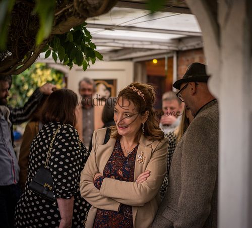 Wedding guest smiling and looking across the ceremony, capturing the joy of the day, photographed by Weddings By Jermaine.