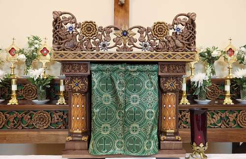 highly carved tabernacle housing with sculptured columns, capitals, bases and crown and symbolic flowers, birds and vines inspired by early gothic, romanesque and scandinavian examples