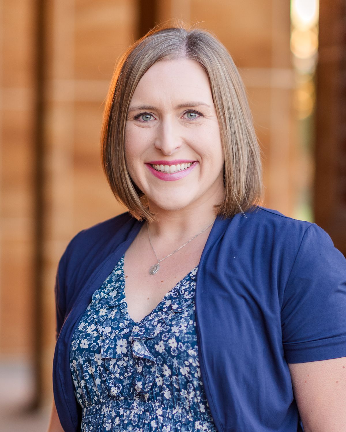 headshot of beautiful mom wearing a flowery blue dress in Wexford Saints John & Paul arches with a Cranberry Township, PA newborn photographer