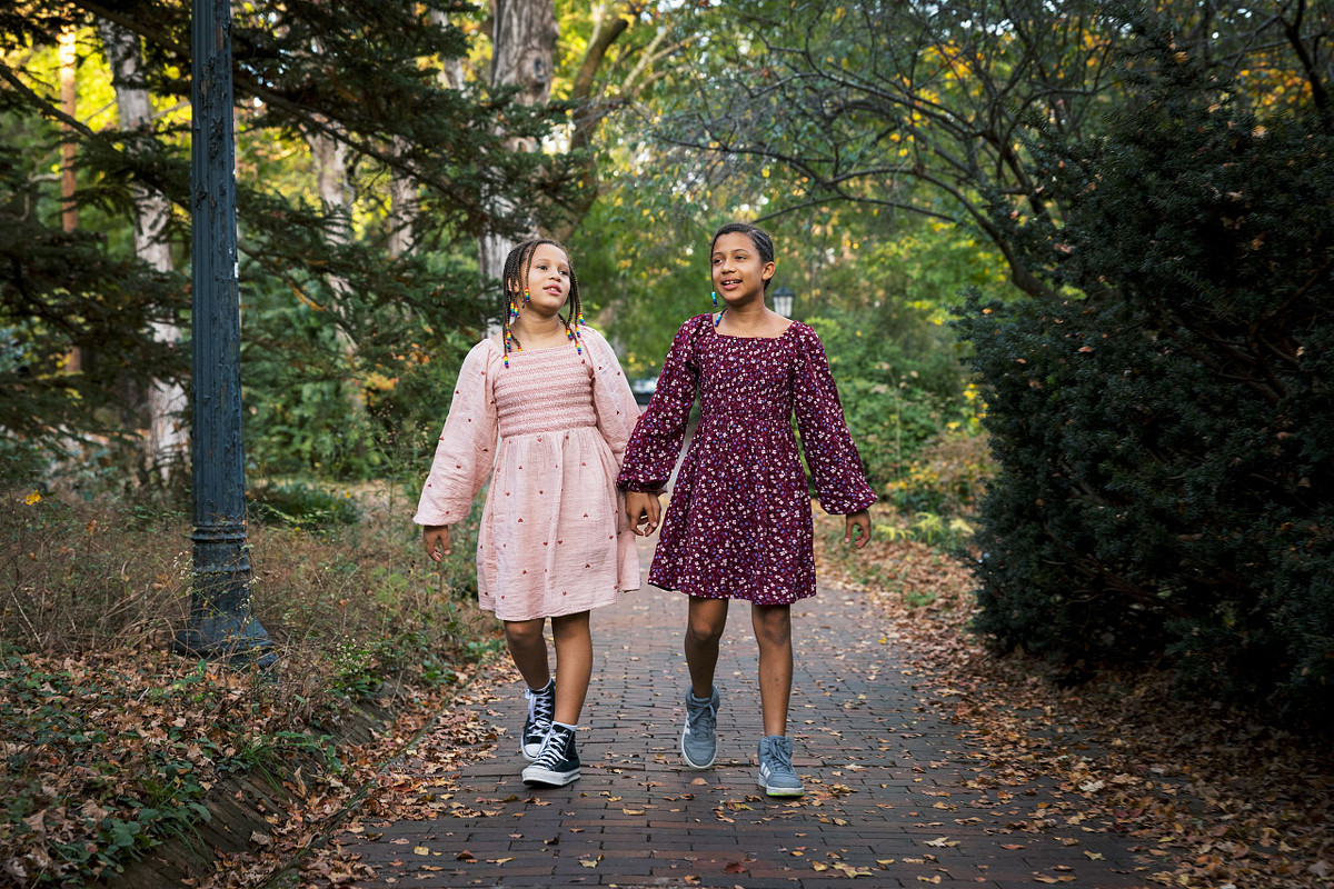 Two sisters walking down a path in Coker Arboretum on UNC's campus in Chapel Hill, NC