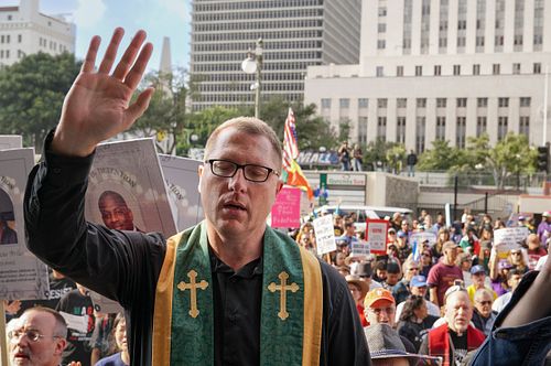Clergy member leads a prayer at Los Angeles immigrants right demonstration