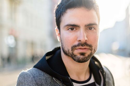 Toni Gojanovi? in a gray jacket and striped hoodie standing on the street.