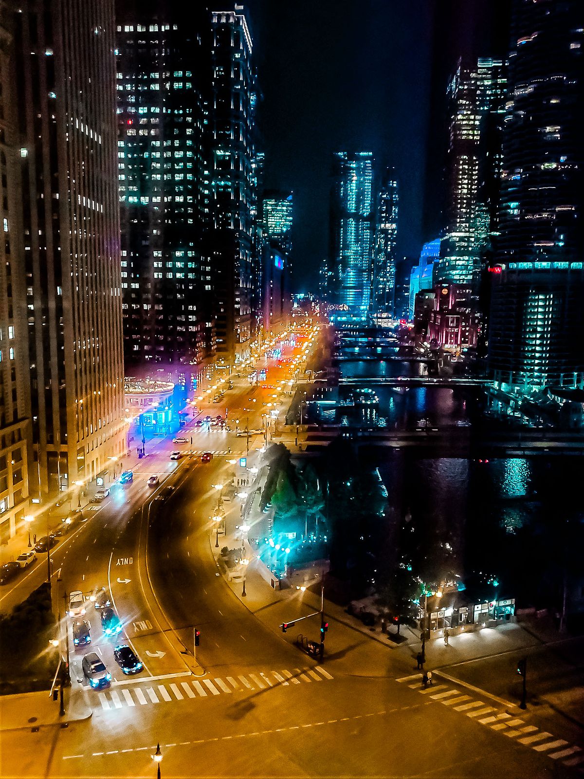 City lights glisten off the river as Chicago's architecture shines under the night sky.