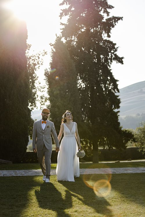 Gli sposi eleganti camminano mano nella mano nel della tenuta santi giacomo e filippo