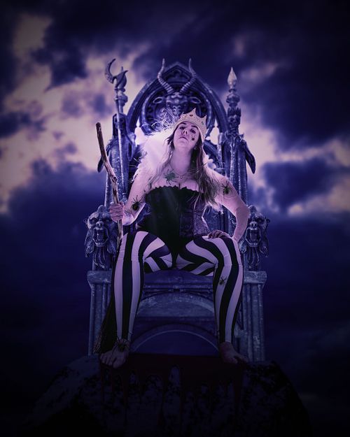 A purple scene of of a crowned woman in striped pants and corset sitting on a throne covered in spiders.