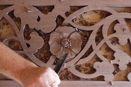 the Poppy flower being carved by hand in the walnut door panel
