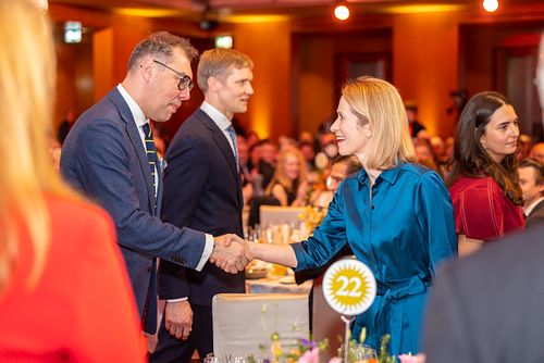 Kaja Kallas shaking hands with a man in a suit at an event at the Axica Convention Centre.