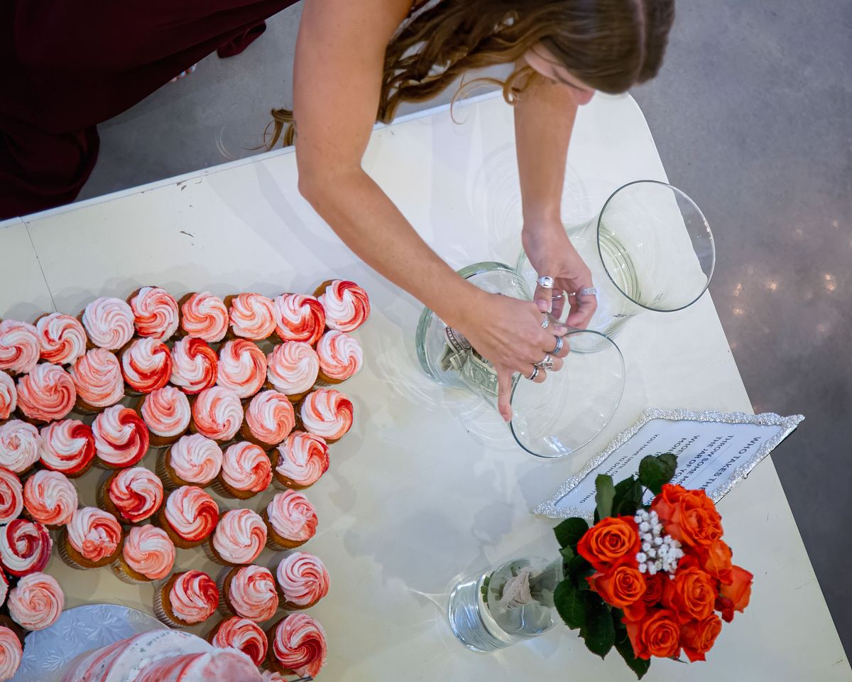 detail shot of cup cakes at Willowbrook, Bridgeville, De with guest counting money in a vase.