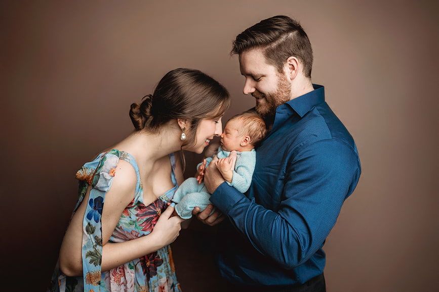 Tender moment of a parent holding their newborn baby, photographed by Amanda Mandola in Houston.