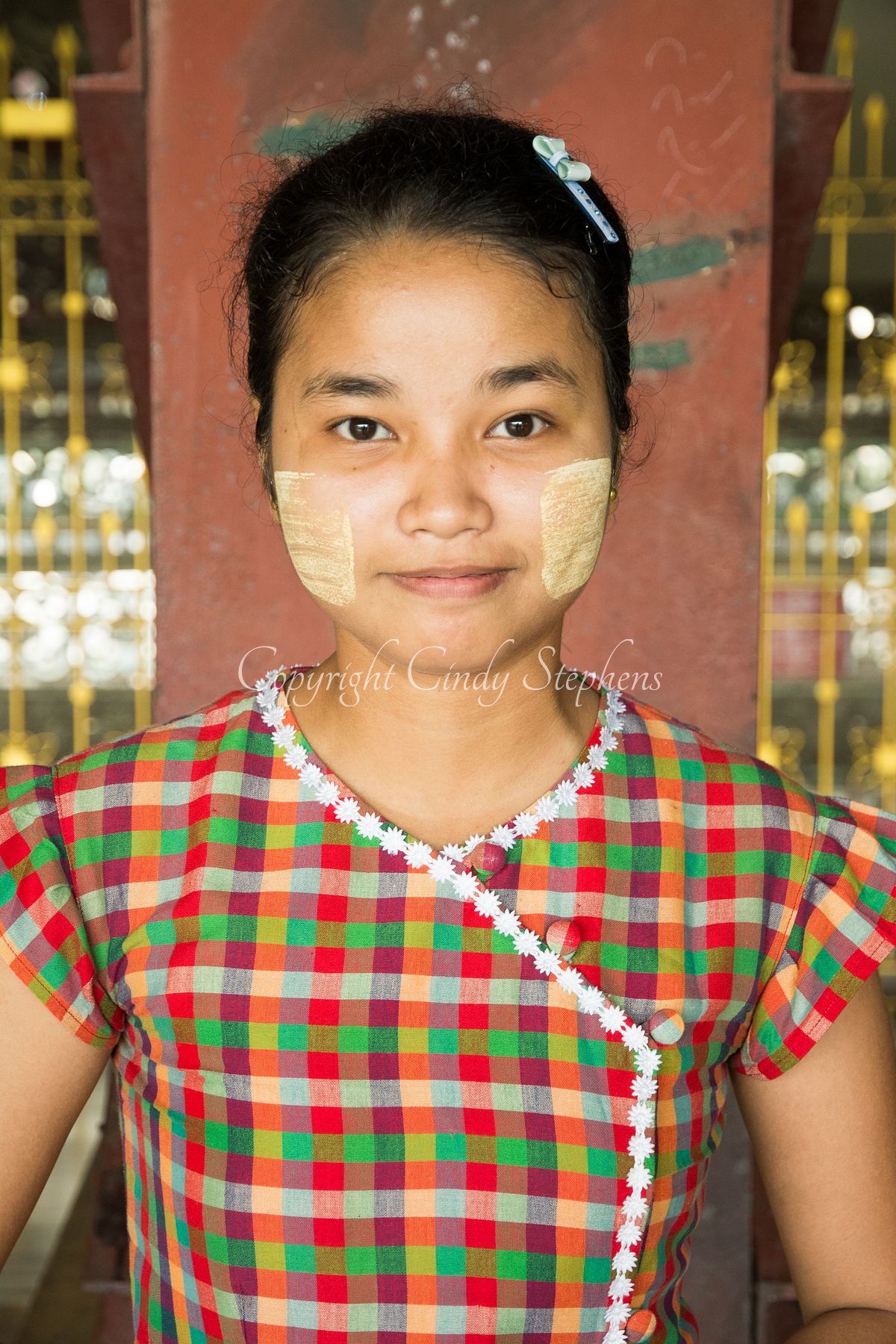 Portrait of a beautiful young girl named Chou at Chauk Htat Gyi Pagoda, adorned with traditional Thanaka on her face.