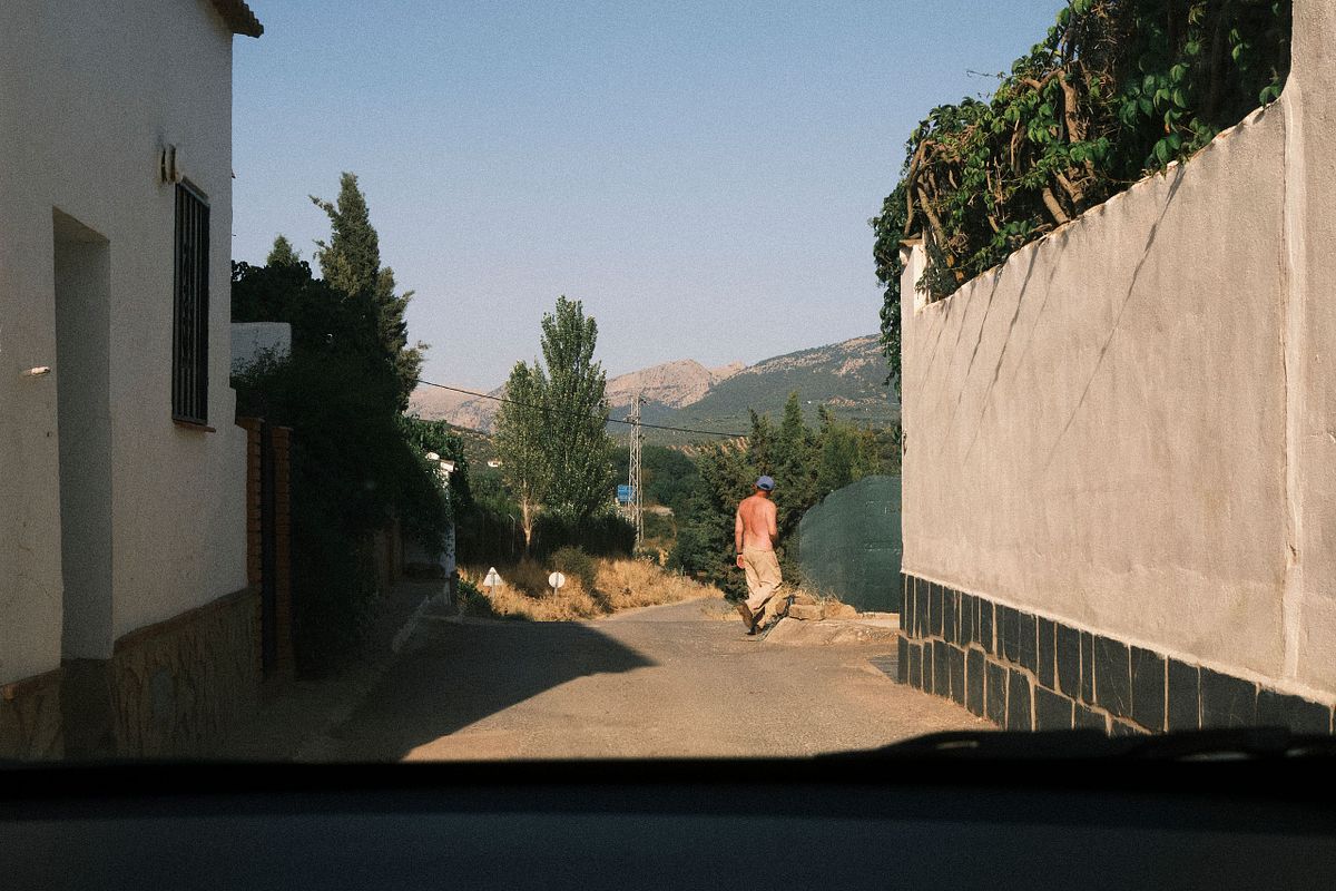 A man walking down a country road in a rural area of Spain, captured by photographer Sandeep Gajula