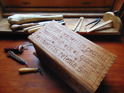 the lid of the cherry box with Latin Bible verse carved on it