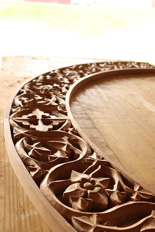 beautiful arch carving in raking light showing the cross, vines and flowers