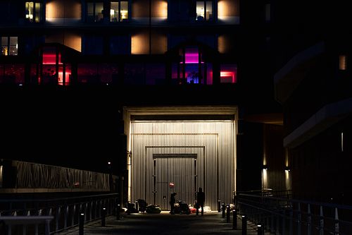 Upplyst industriell port med siluetter och färgade fönster i bakgrunden