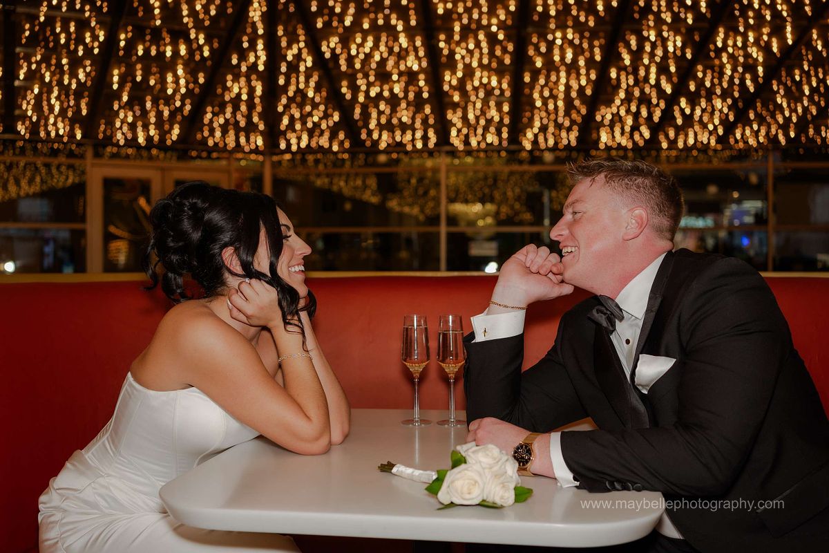 Romantic elopement photos at Carousel Bar in Downtown Las Vegas with couple celebrating with champagne