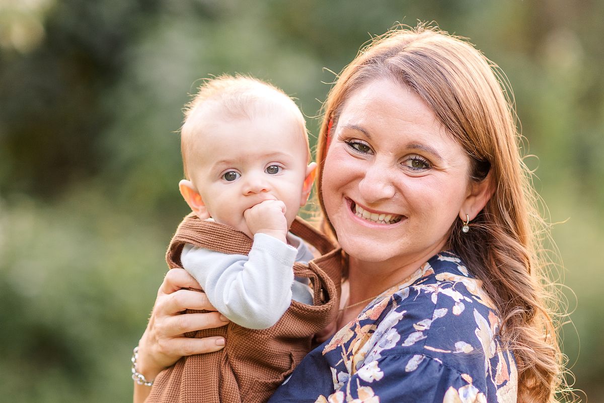 New mom holding her baby in fall background