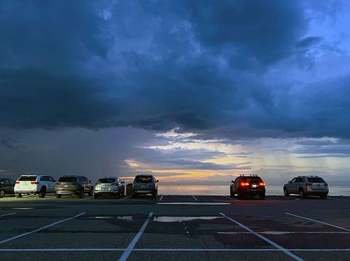 cars parked at the beach at night.