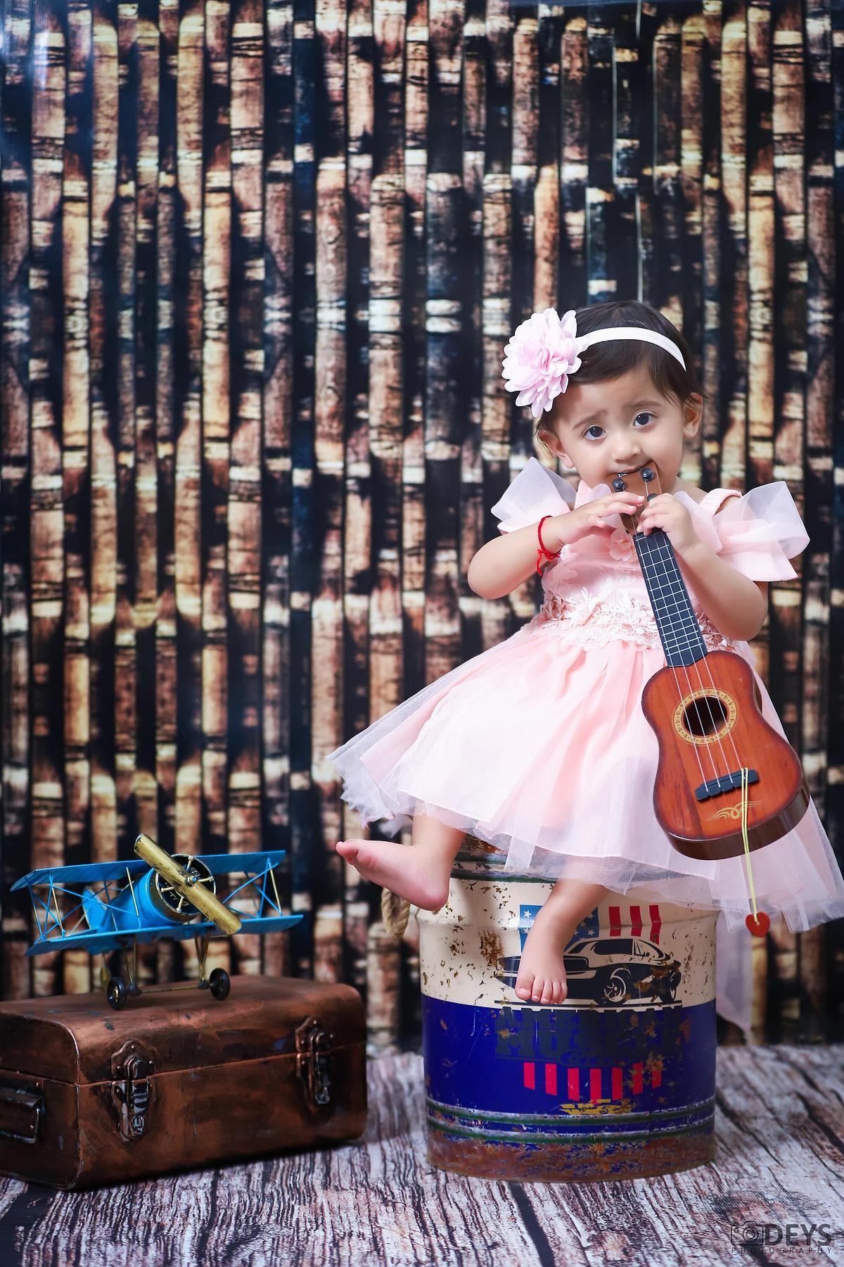 Indoor 1st birthday photoshoot of baby girl with guitar