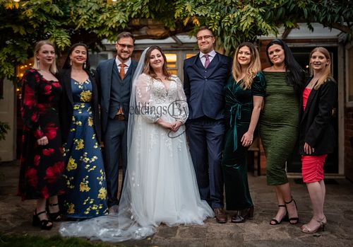 Bride surrounded by her family and friends on her wedding day, smiling and celebrating together, photographed by Weddings By Jermaine.