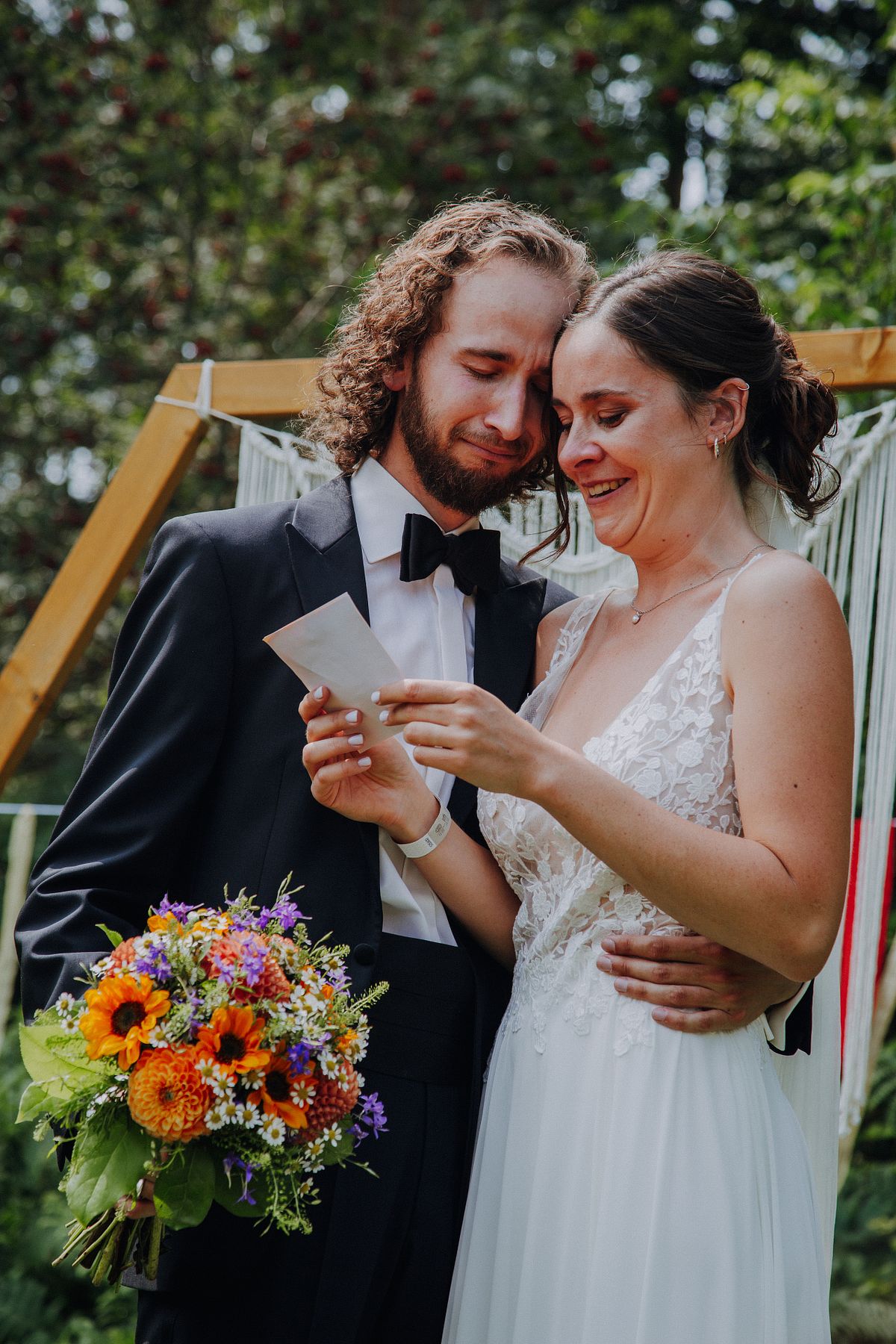 Paar steht lachend im Wald und reagiert &uuml;berrascht auf eine Karte, kreatives und abenteuerliches Paar-Shooting in der N&auml;he von K&ouml;ln.