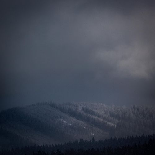 Pente de montagne sous nuages bas.