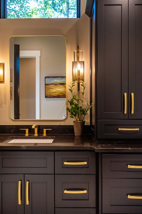 Vignette of satin brass wall sconce and custom vanity