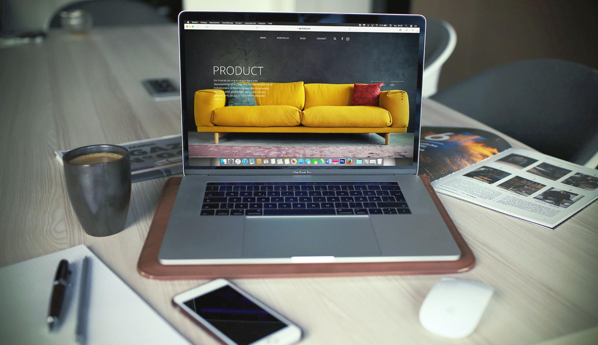 a laptop on a table with coffee on the side