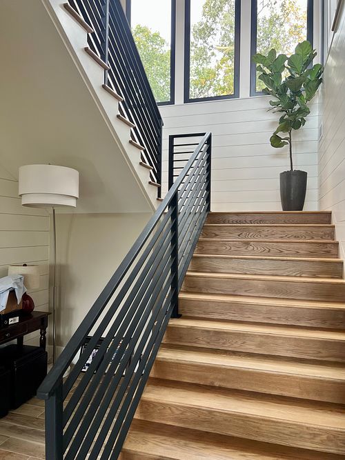 Daylit stair well with White oak steps; black flat bar railing