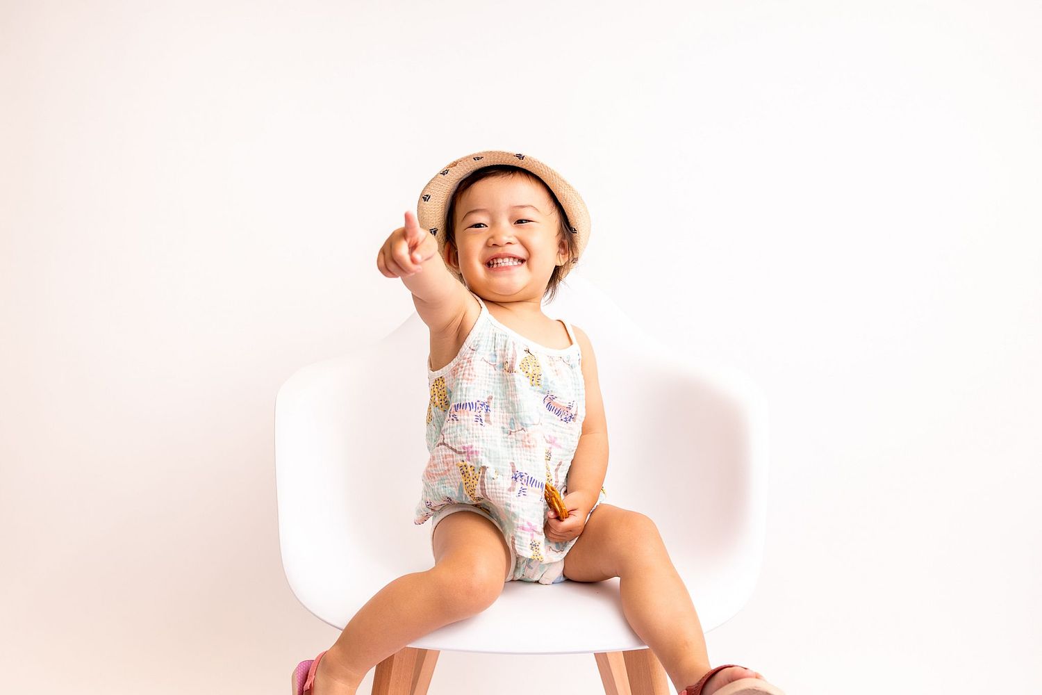 Monthly baby growth photo on a chair taken by Basel photographer capturing baby's cute smile