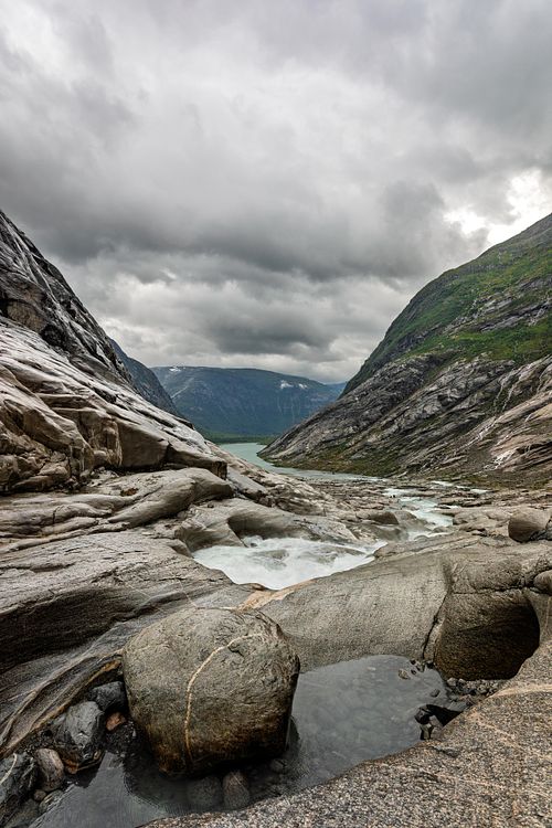 Rochers lissés au bord d’un plan d’eau nordique.