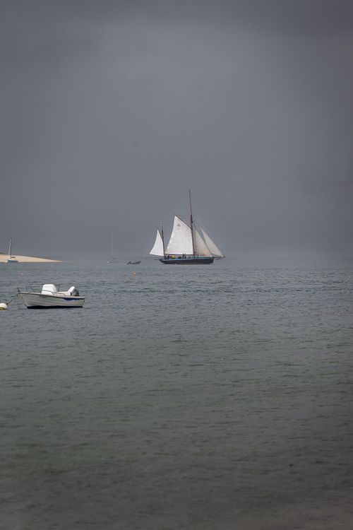 Deux voiliers sur mer grise, ciel bas.