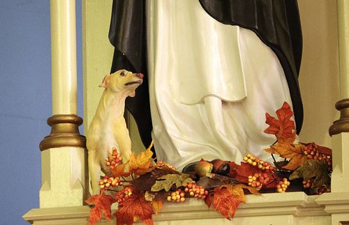 Small dog statue at the foot of the St Dominic Statue before repainting and restoration