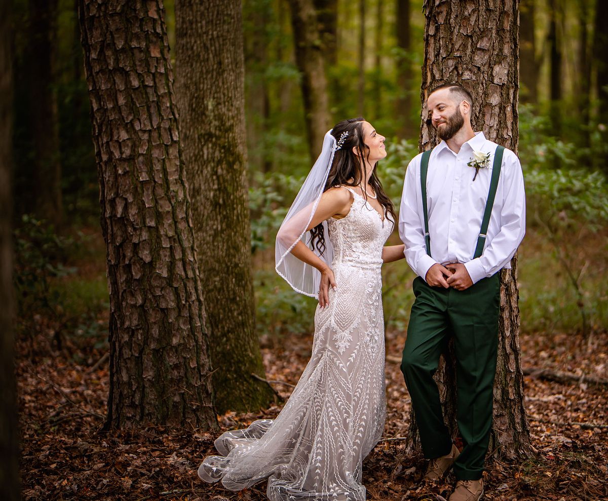 bride is looking at the groom standing by a tree after the ceremony in forest at a eastern shore wedding