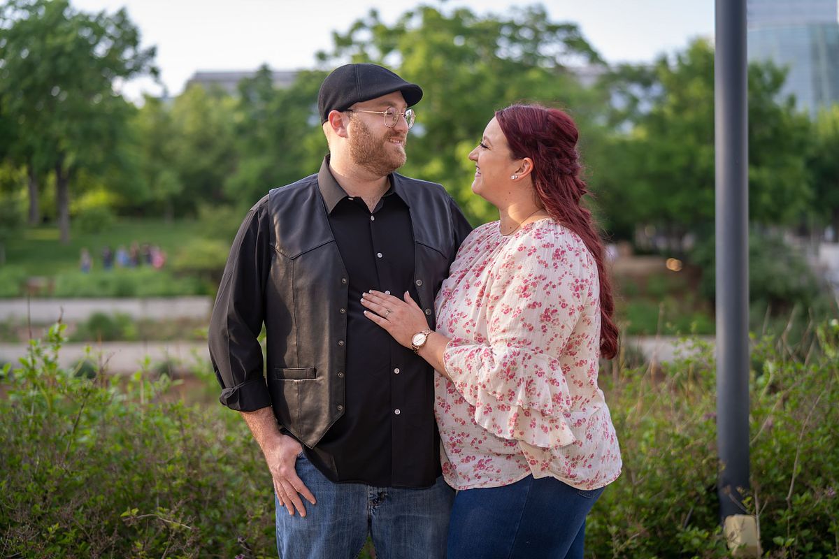 Engaged couple sharing a candid moment during golden hour in Oklahoma.