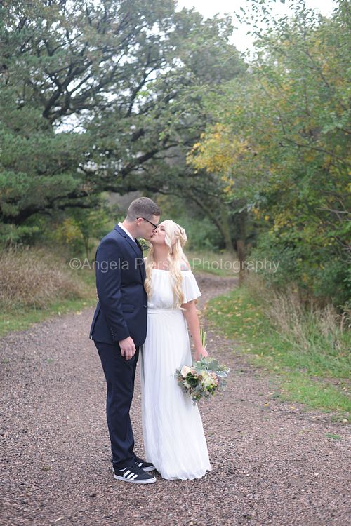Bride and Groom standing on a wooded trail kissing- Sioux Falls Wedding Photographer