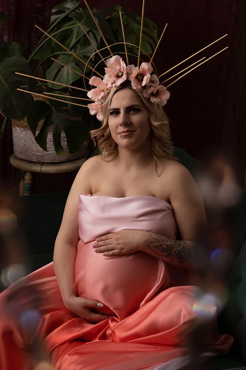 Expecting mother wearing a flower crown and satin dress